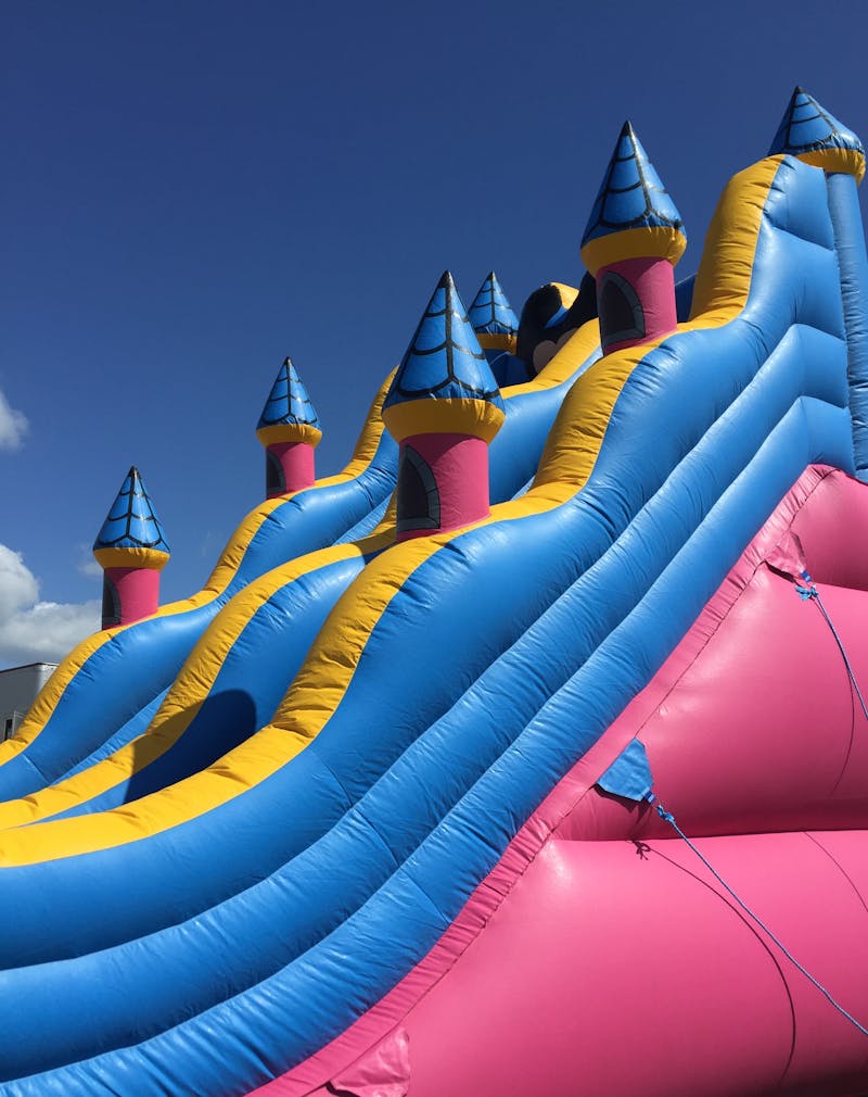 Large inflatable combo unit with castle turrets and multiple slides